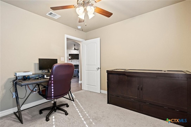 carpeted home office with ceiling fan