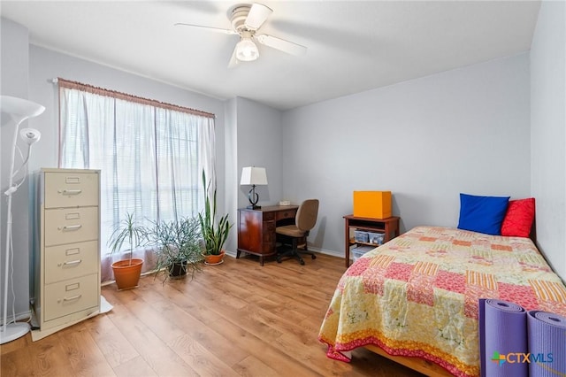 bedroom with ceiling fan, baseboards, and light wood-type flooring