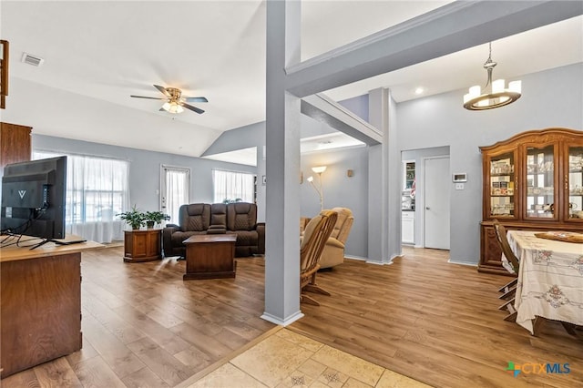 living room with high vaulted ceiling, a ceiling fan, wood finished floors, baseboards, and visible vents