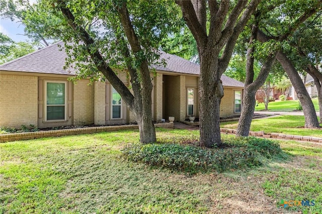 3002 Arrowhead Dr, Temple, TX 76502 - view of front facade featuring a shingled roof, a front yard, and brick siding