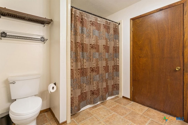 bathroom with a shower with shower curtain and toilet