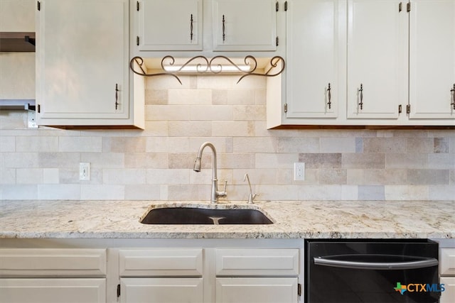 kitchen with white cabinets, black dishwasher, backsplash, and sink