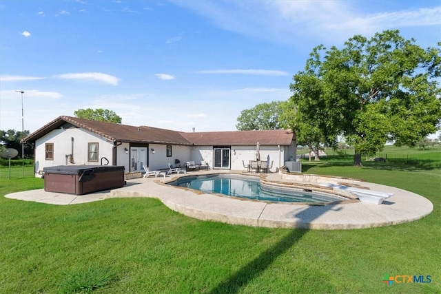 rear view of property with central AC unit, a pool with hot tub, a yard, and a patio