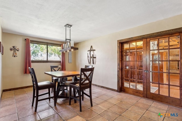 dining space featuring tile patterned floors, french doors, and a textured ceiling