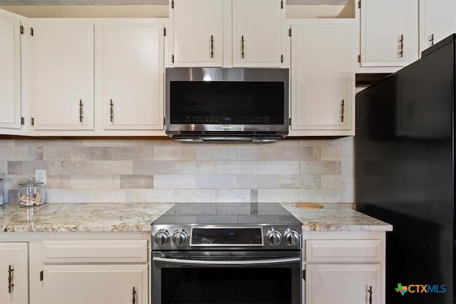 kitchen featuring white cabinets, stainless steel appliances, and tasteful backsplash