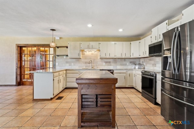 kitchen with a center island, hanging light fixtures, tasteful backsplash, light tile patterned floors, and appliances with stainless steel finishes