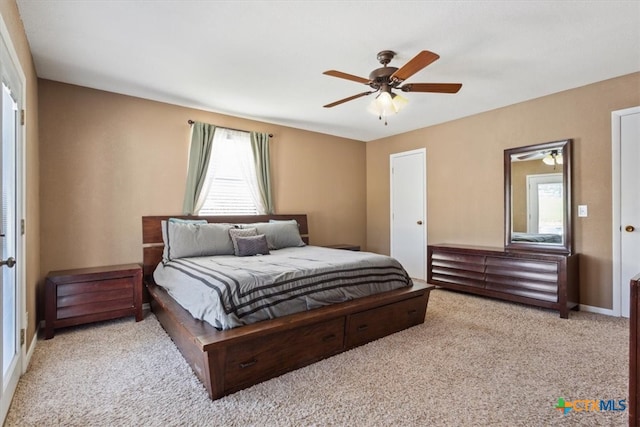 carpeted bedroom featuring multiple windows and ceiling fan