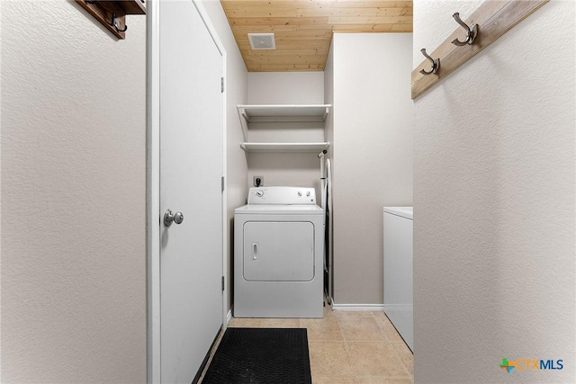 clothes washing area with visible vents, light tile patterned floors, laundry area, wooden ceiling, and separate washer and dryer