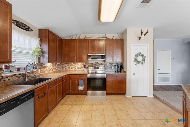 kitchen featuring light tile patterned flooring, visible vents, appliances with stainless steel finishes, and a sink