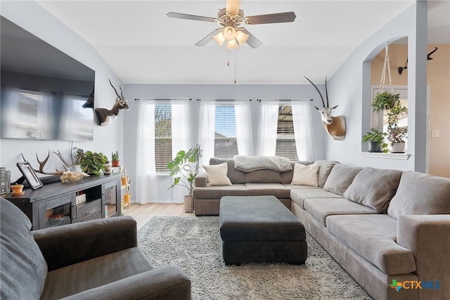 living room featuring lofted ceiling, a ceiling fan, and wood finished floors