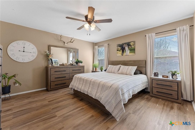 bedroom featuring a ceiling fan, light wood-style floors, and baseboards