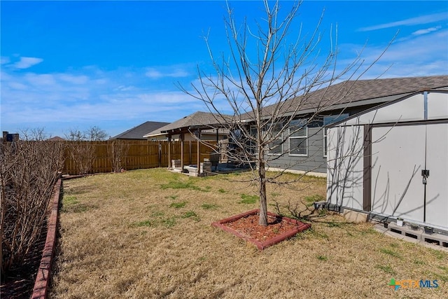 view of yard featuring an outbuilding, a fenced backyard, and a shed