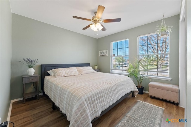 bedroom with ceiling fan, baseboards, and wood finished floors