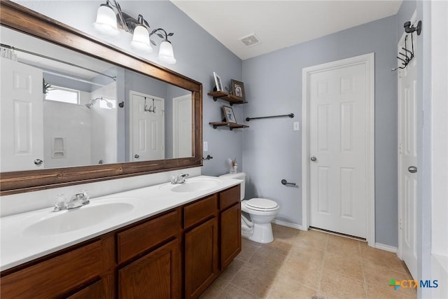 full bath featuring a sink, visible vents, toilet, and double vanity