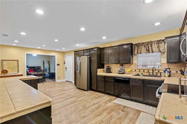 501 Hathaway St, Victoria, TX 77904 - kitchen featuring stainless steel appliances, light wood finished floors, dark brown cabinets, decorative backsplash, and recessed lighting