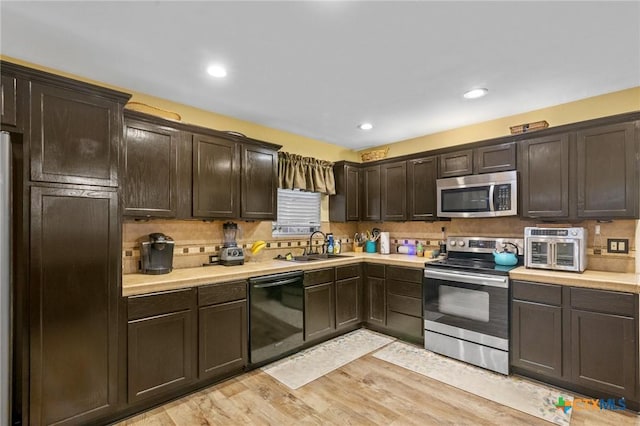 501 Hathaway St, Victoria, TX 77904 - kitchen featuring stainless steel appliances, dark brown cabinets, light countertops, backsplash, and light wood-type flooring