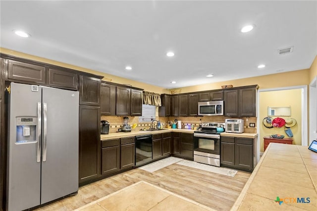 501 Hathaway St, Victoria, TX 77904 - kitchen with appliances with stainless steel finishes, dark brown cabinetry, light countertops, and recessed lighting