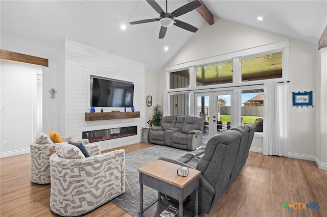 living area featuring french doors, a glass covered fireplace, wood finished floors, high vaulted ceiling, and beamed ceiling