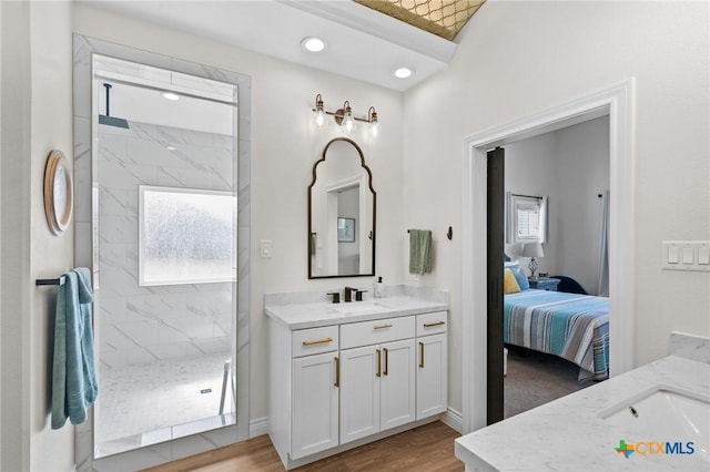 bathroom with wood finished floors, a marble finish shower, vanity, and connected bathroom