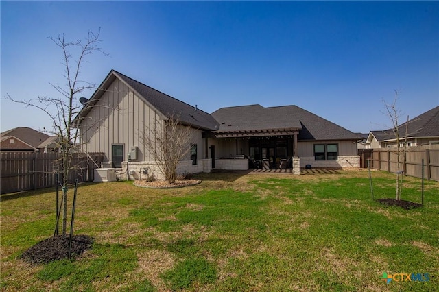 rear view of property featuring a patio area, a fenced backyard, a lawn, and board and batten siding