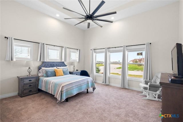 bedroom with multiple windows, carpet, a towering ceiling, and baseboards