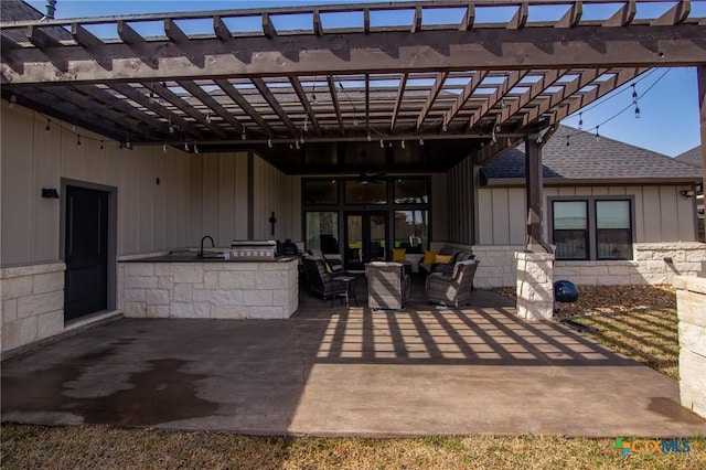 view of patio with an outdoor kitchen, an outdoor living space, and a pergola