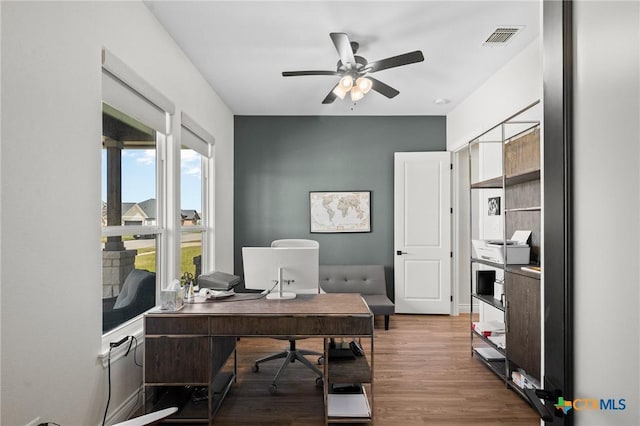 office space featuring ceiling fan, visible vents, and wood finished floors