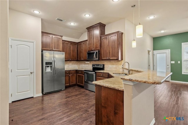 kitchen with kitchen peninsula, appliances with stainless steel finishes, light stone countertops, sink, and pendant lighting