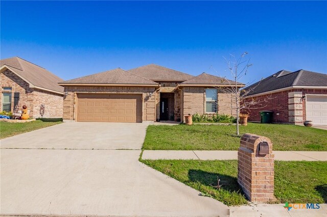 609 Mason Cir, Victoria, TX 77904 - single story home featuring brick siding, an attached garage, driveway, and a front lawn