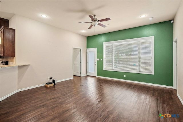 empty room with ceiling fan and dark hardwood / wood-style flooring