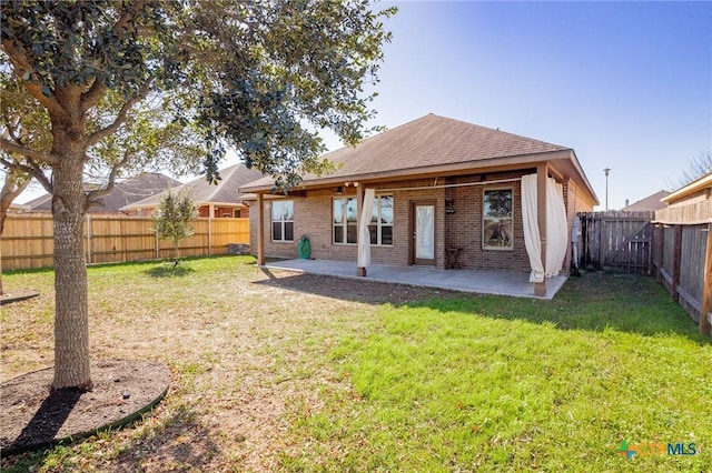 rear view of property with a yard and a patio