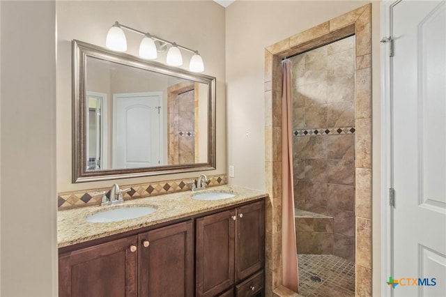 bathroom featuring tiled shower and vanity