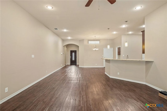 unfurnished living room with dark hardwood / wood-style floors and ceiling fan