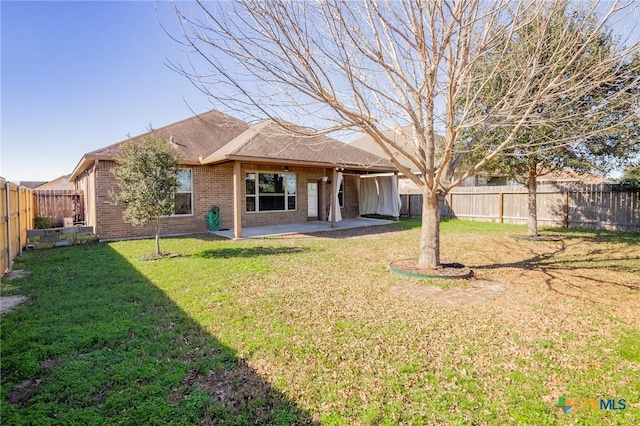 back of house featuring a yard and a patio area