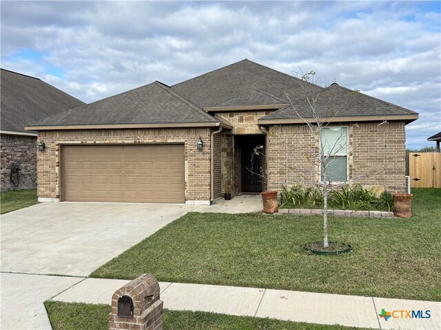 609 Mason Cir, Victoria, TX 77904 - view of front facade with a garage, fence, a front yard, brick siding, and concrete driveway