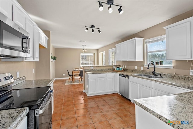 229 Rocky Ridge Dr, New Braunfels, TX 78130 - kitchen with stainless steel appliances, a sink, a peninsula, and white cabinets