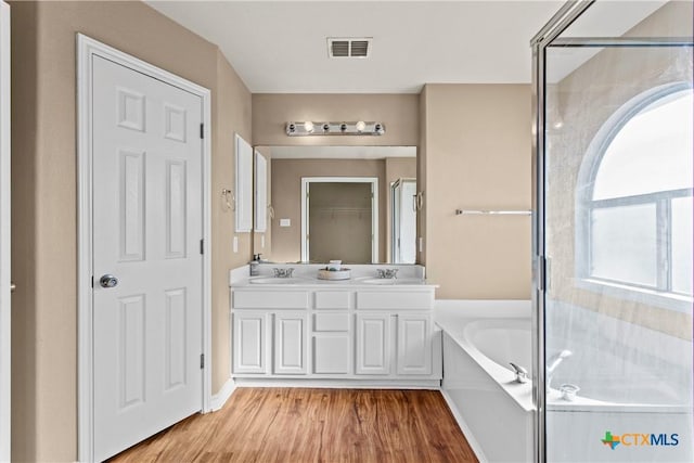 229 Rocky Ridge Dr, New Braunfels, TX 78130 - full bathroom featuring wood finished floors, a bath, double vanity, and an enclosed shower