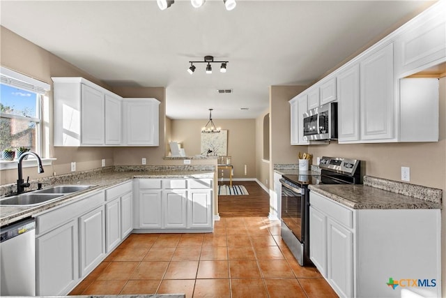 229 Rocky Ridge Dr, New Braunfels, TX 78130 - kitchen with stainless steel appliances, a sink, a peninsula, white cabinetry, and light tile patterned floors