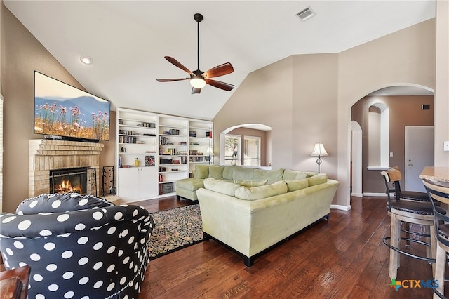 living room featuring visible vents, a fireplace, arched walkways, ceiling fan, and wood-type flooring