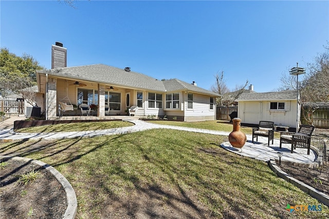 back of property featuring a patio, fence, an outdoor structure, and ceiling fan