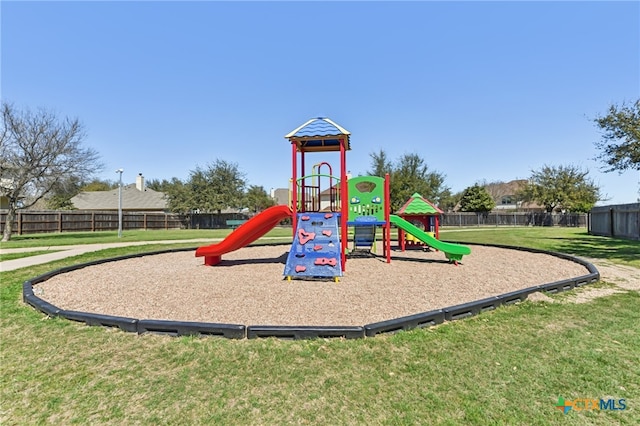 community playground featuring a yard and fence