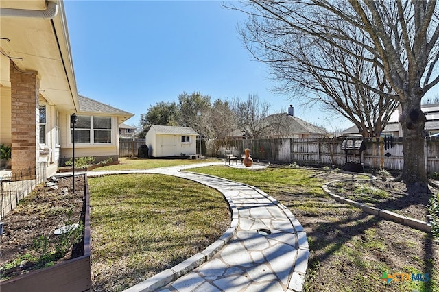 view of yard featuring an outbuilding, a storage unit, and a fenced backyard