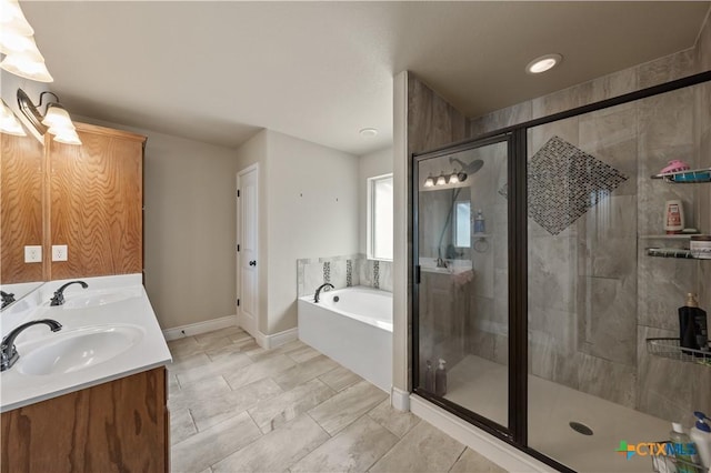bathroom with baseboards, a shower stall, a sink, and a garden tub