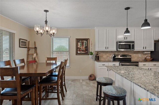 dining area with an inviting chandelier and baseboards