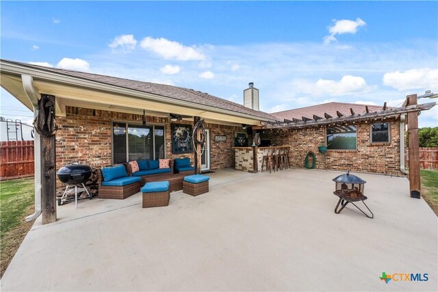 rear view of house featuring fence, outdoor dry bar, a patio, and a chimney
