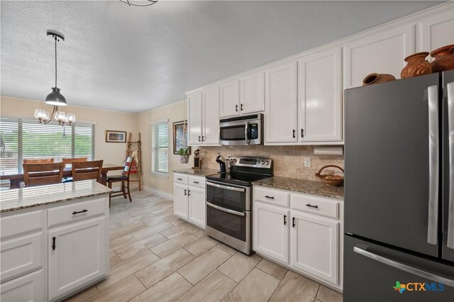 kitchen featuring white cabinets, tasteful backsplash, a notable chandelier, decorative light fixtures, and stainless steel appliances