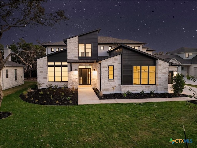 back house at night with a lawn