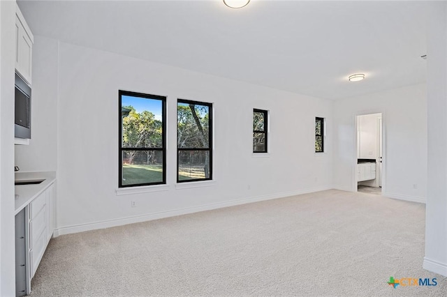 unfurnished living room featuring light carpet