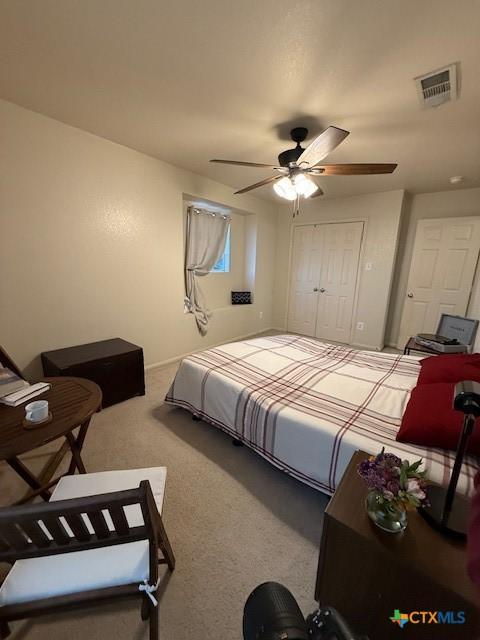 carpeted bedroom with ceiling fan and a closet