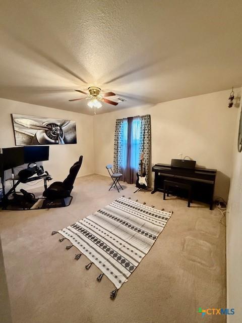 sitting room featuring ceiling fan and a textured ceiling